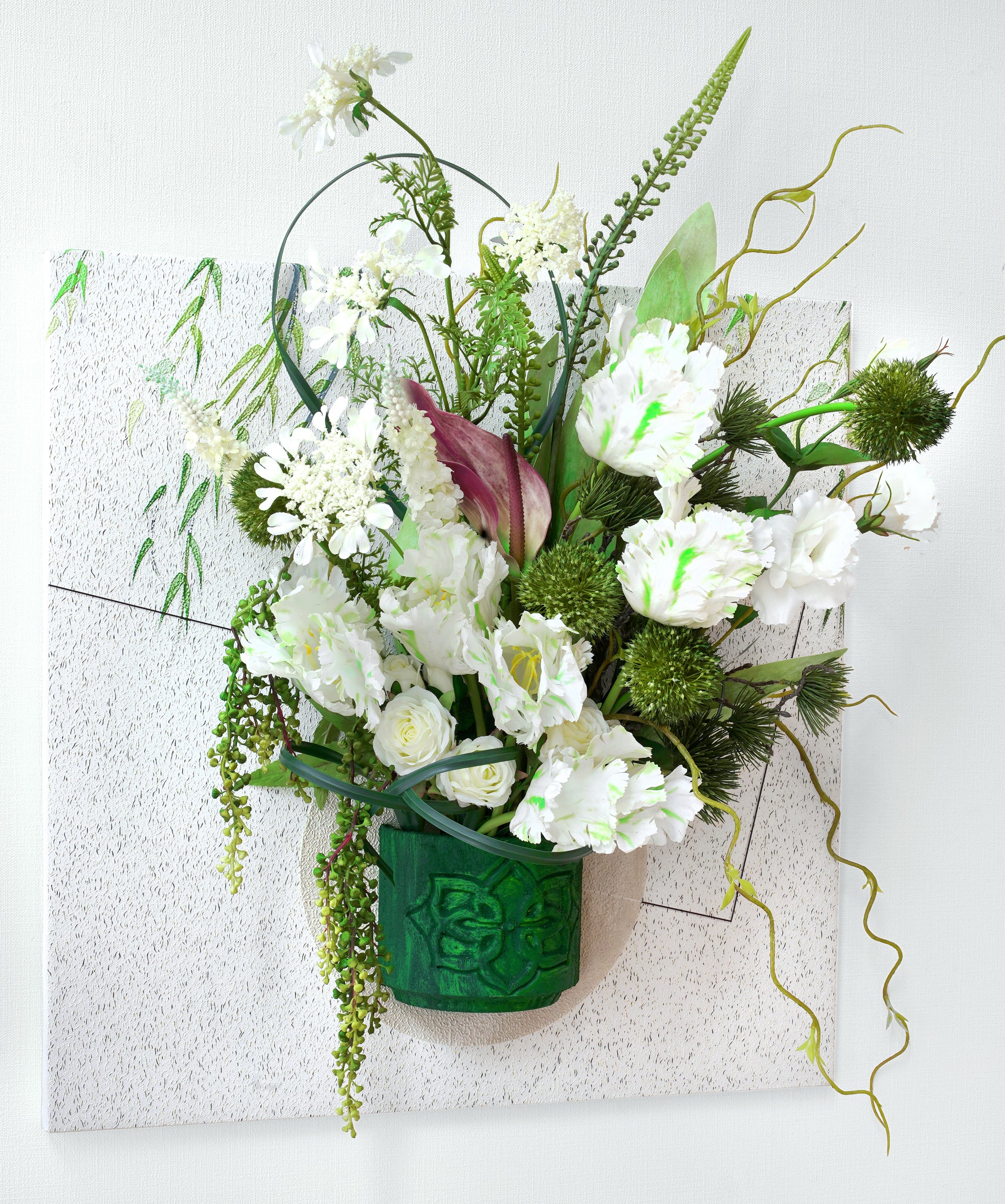Bouquet of white flowers in a green vase on a textured white background